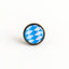 Minimalistisches Produktbild vom Bayern Pin – runder Pin mit blau-weißem Rautenmuster und altkupferfarbener Metallfassung
