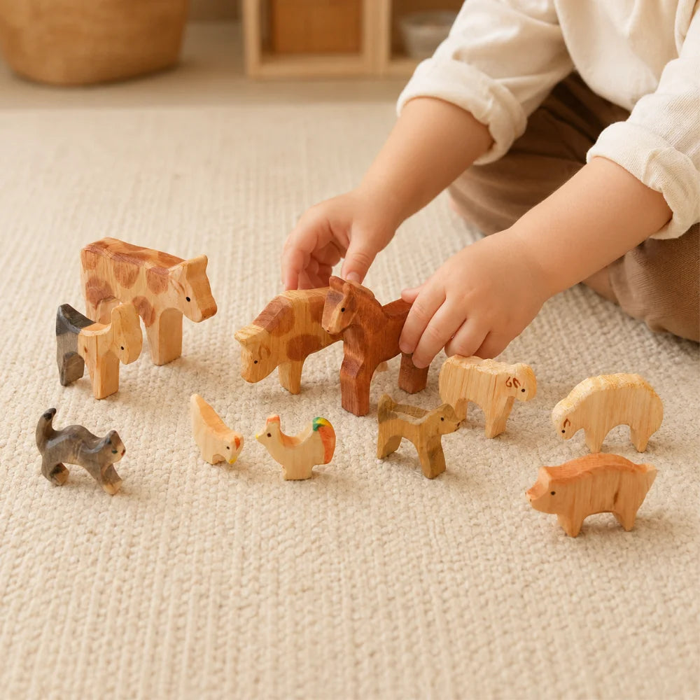 Kind spielt mit kleinen Holz-Tieren im Kinderzimmer