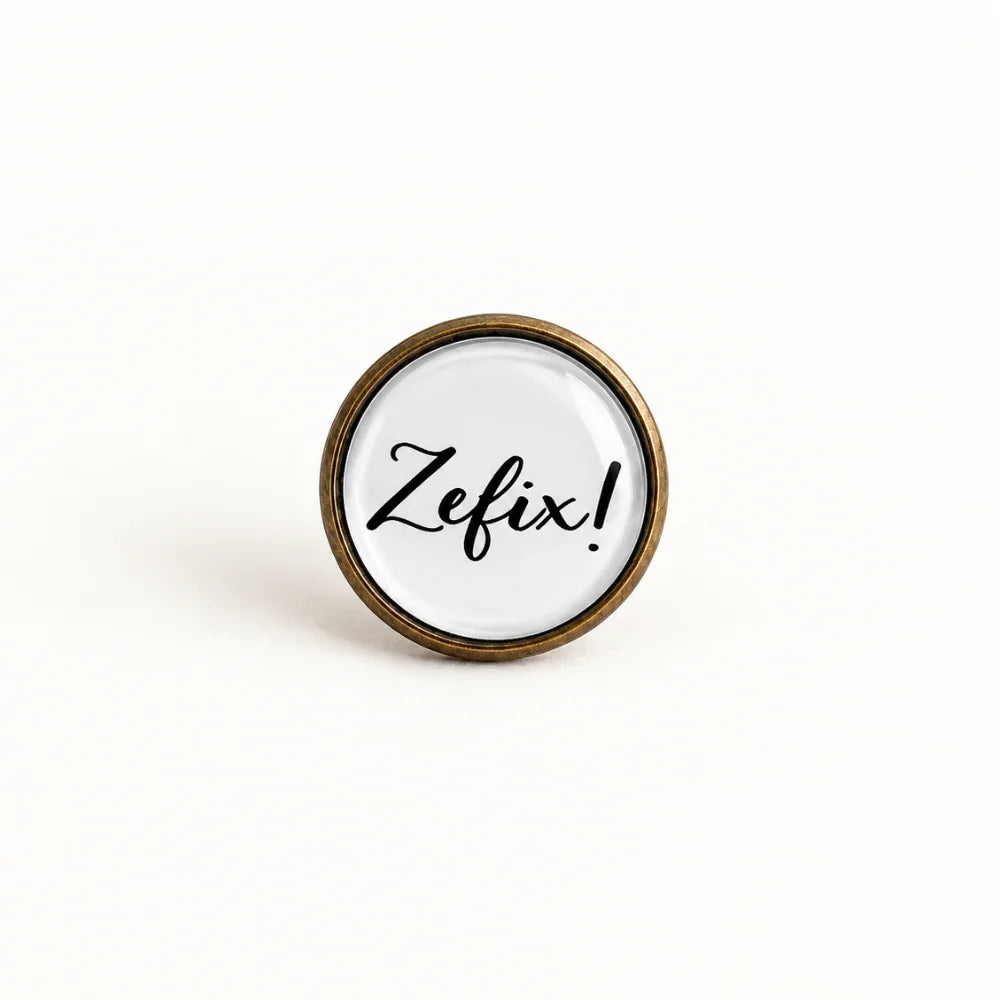 Bayern Pin „Zefix!“ in Altkupfer – runder 16-mm-Ansteckpin mit weißem Motiv und Glaslinse