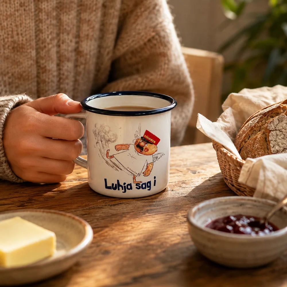 Engel Aloisius Emaille-Tasse „Luhja sag i“ in gemütlicher Frühstücksszene auf Holztisch