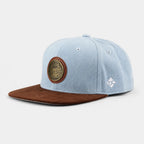 Hellblaue Hofbräuhaus München Snapback-Cap mit braunem Schirm auf hellem Hintergrund