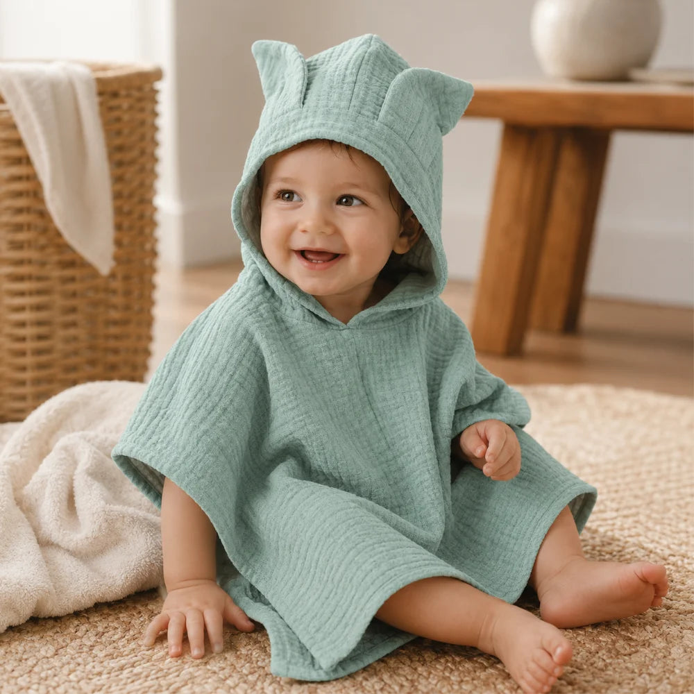 Kleinkind trägt einen aquamarinfarbenen Musselin-Badeponcho mit Kapuze und Öhrchen