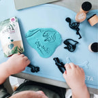 Kind spielt kreativ mit Knete auf der KNETÄ Silikon-Tischunterlage am Kindertisch