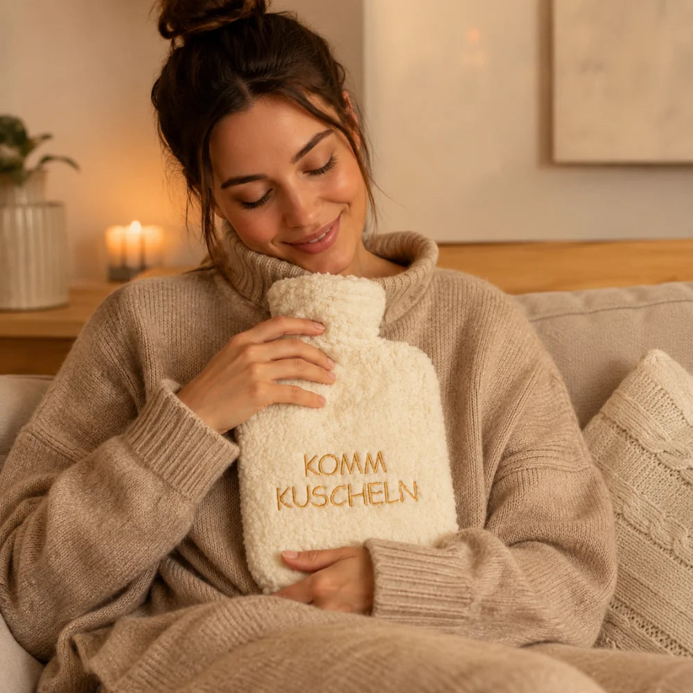Frau freut sich über die EFIE Wärmflasche „Komm kuscheln“ als liebevolles Geschenk für gemütliche Stunden.