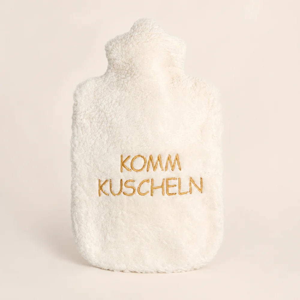 EFIE Wärmflasche „Komm kuscheln“ mit weichem Bio-Baumwollbezug und goldfarbener Stickerei auf hellem Hintergrund.