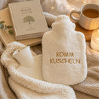 EFIE Wärmflasche „Komm kuscheln“ neben Buch, Tee und Kerzenlicht für entspannte Wohlfühlmomente.
