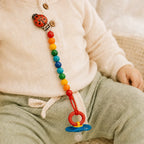 Schnullerkette mit Marienkäfer-Clip an Babykleidung befestigt